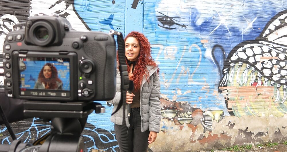 Woman reporter being recorded by a camera