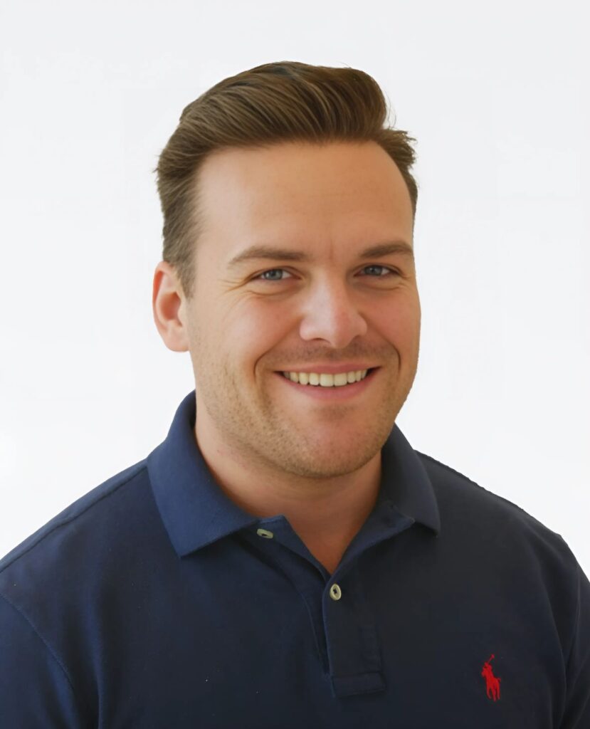 Professional headshot of a smiling man in a blue polo - Chandler Worley