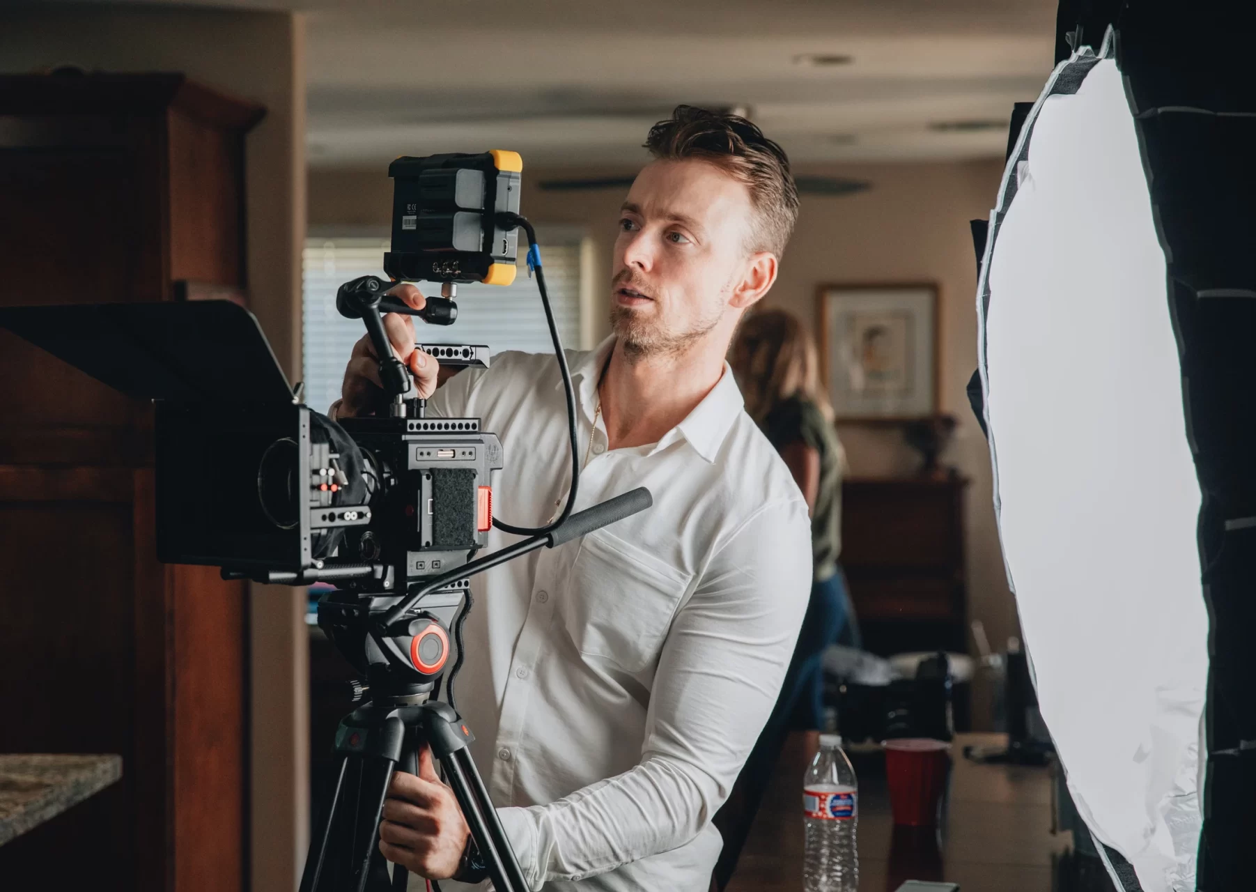 Man adjusting a film cameras attached monitor during a shoot