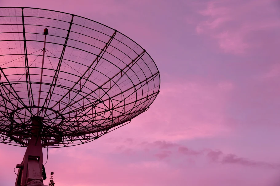 Satellite dish pointing at the sky with an evening sky in the background