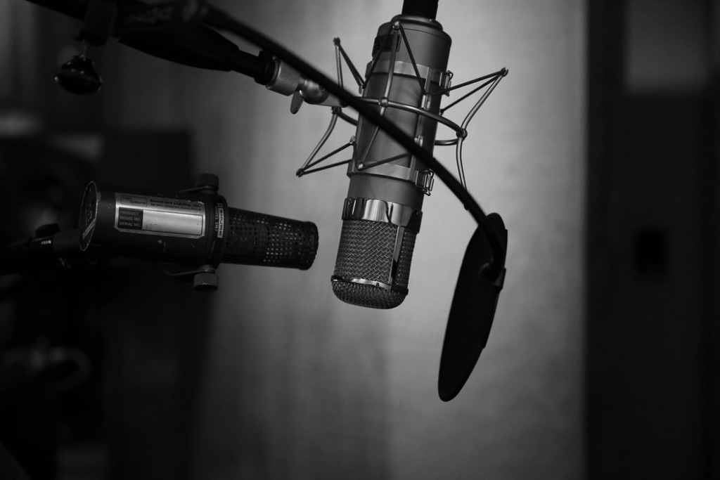 Black and white close up of a microphone in a sound booth