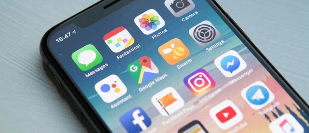 phone screen displaying home apps on a blue table