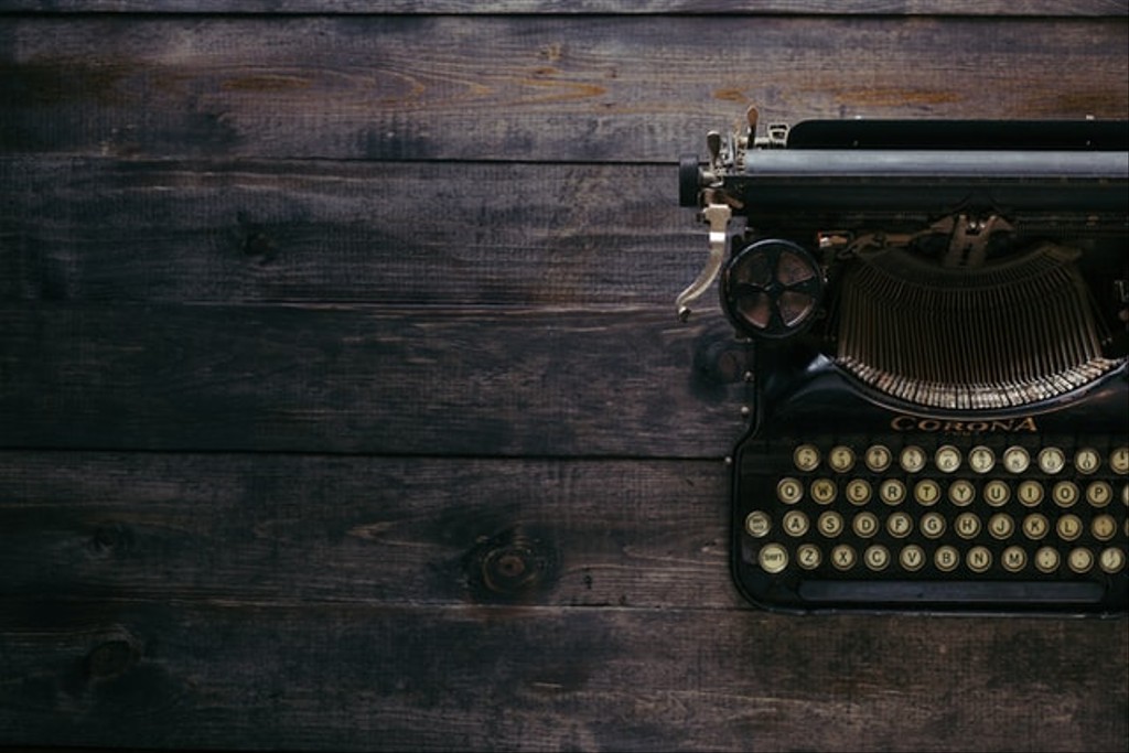 Black Corona typewriter on a dark wood table