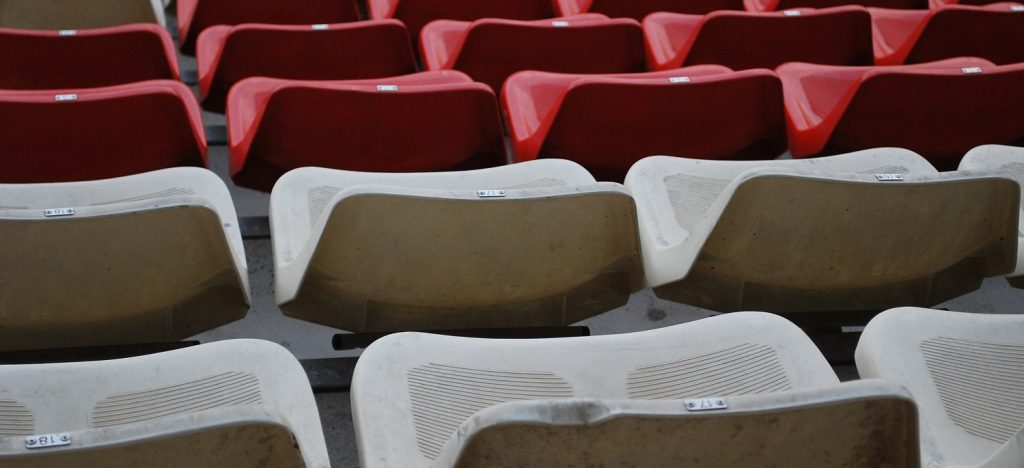 close up image of empty red and white stadium seats
