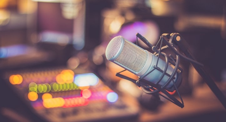 Radio mic in focus in front of out of focus audio mixing panel