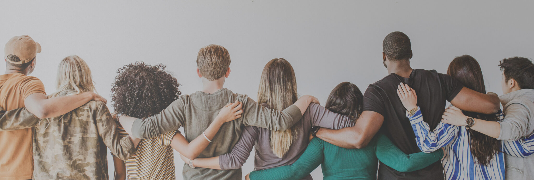 Diverse group of people with arms around each other