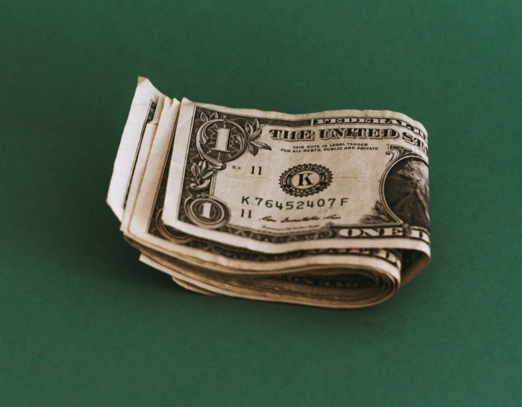 Smile pile of one dollar bills folded in half on a green background