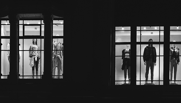 Black and white shot of fashion store mannequins through windows