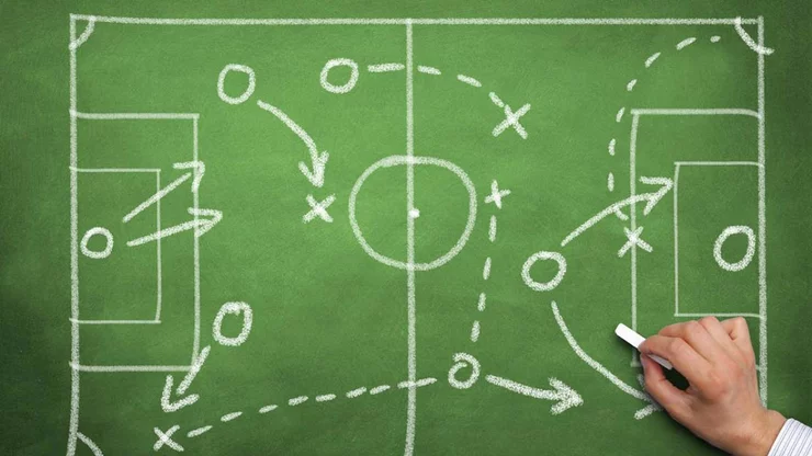 Soccer plays sketched on a green mat with a white chalk