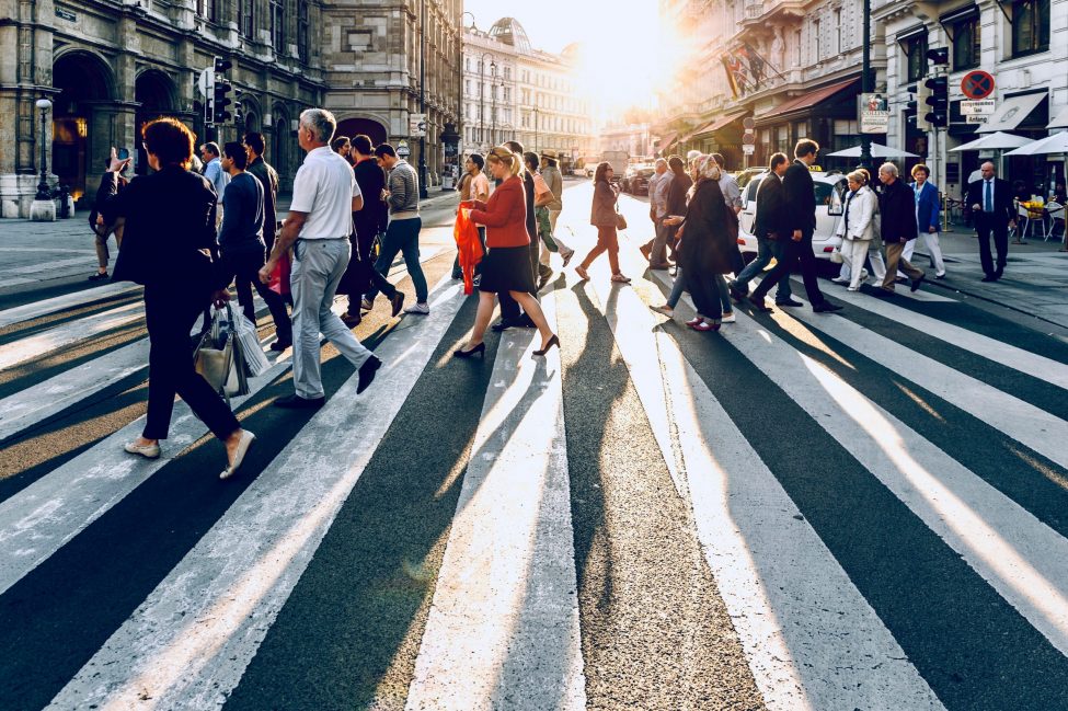 Sideview of a street crossing with many people crossing