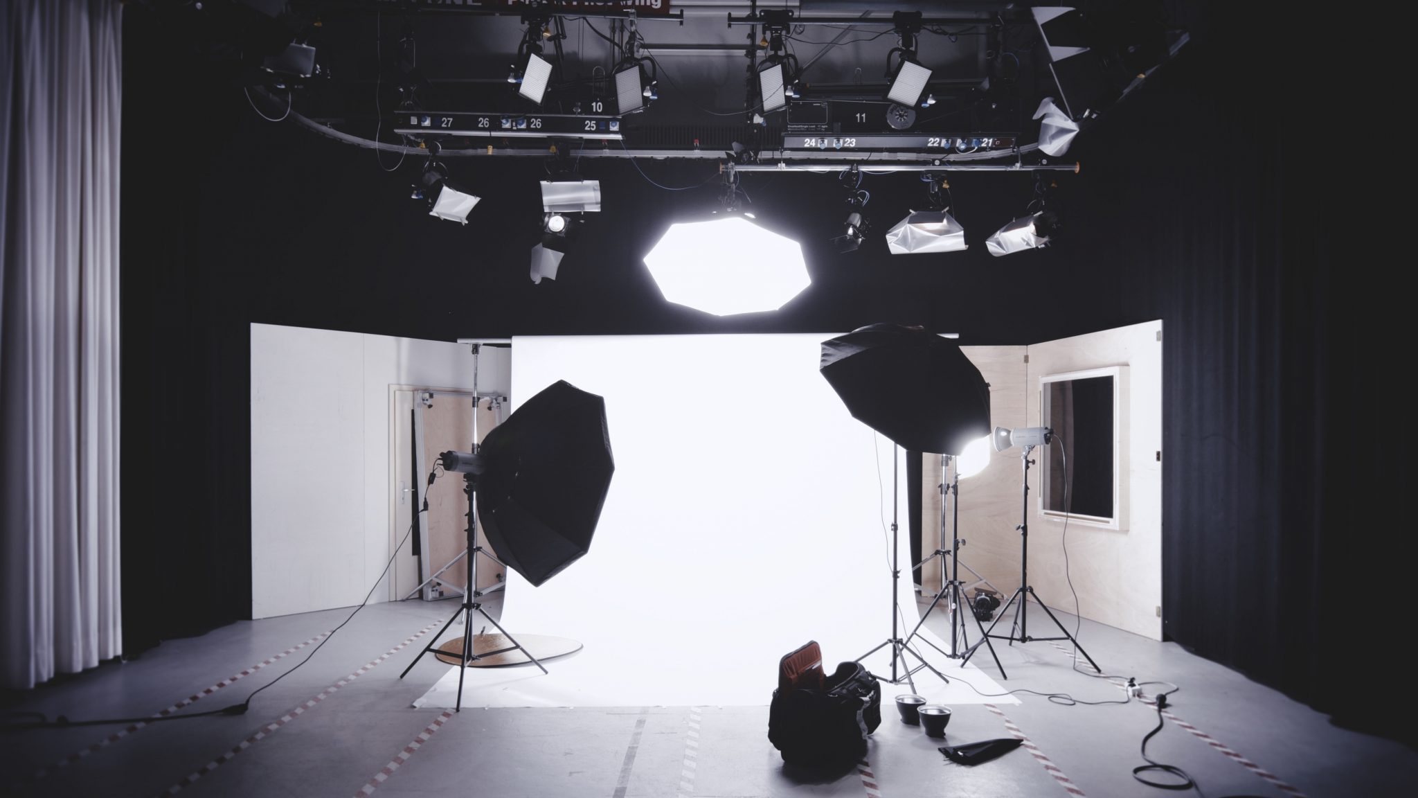 Black video recording room with full camera, sound, and lighting setup for recording