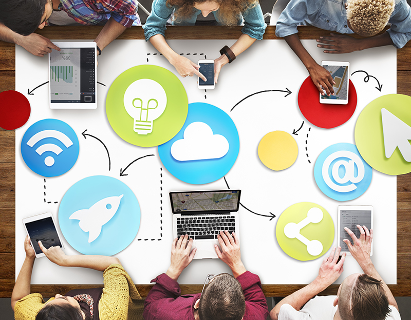 Graphic of 5 people using devices at a table with various icons on the table