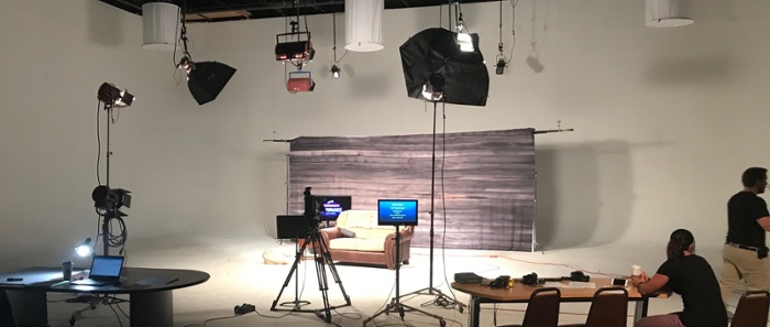 White video recording room setup with full camera and lighting equipment for a interview scene