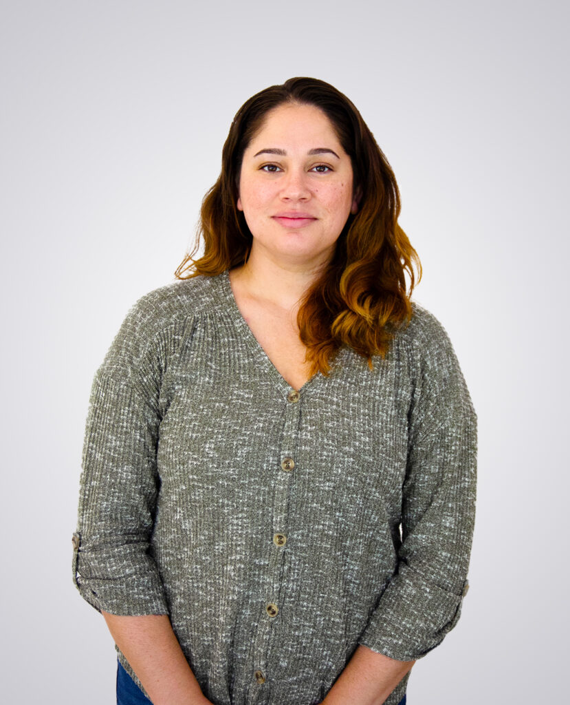 Professional headshot of a woman smiling wearing a green sweater