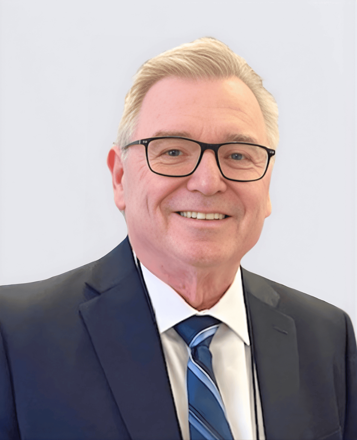 Professional headshot of a smiling man in a suit