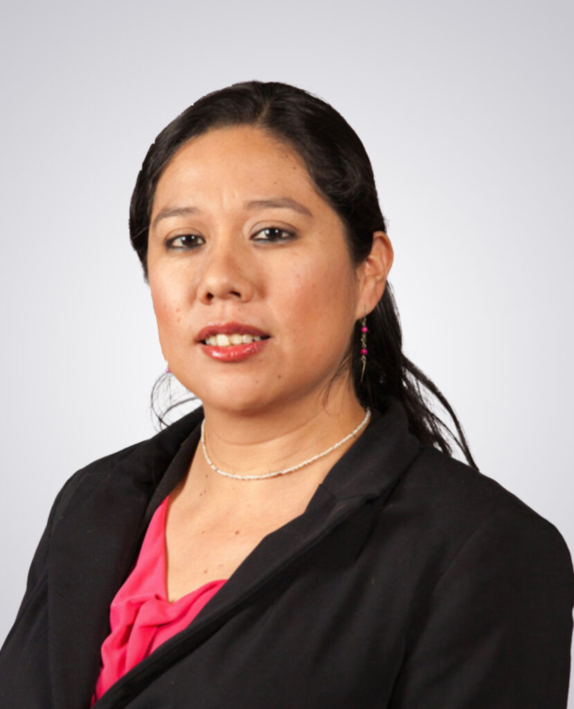 Professional headshot of a woman with black hair smiling wearing a black blazer