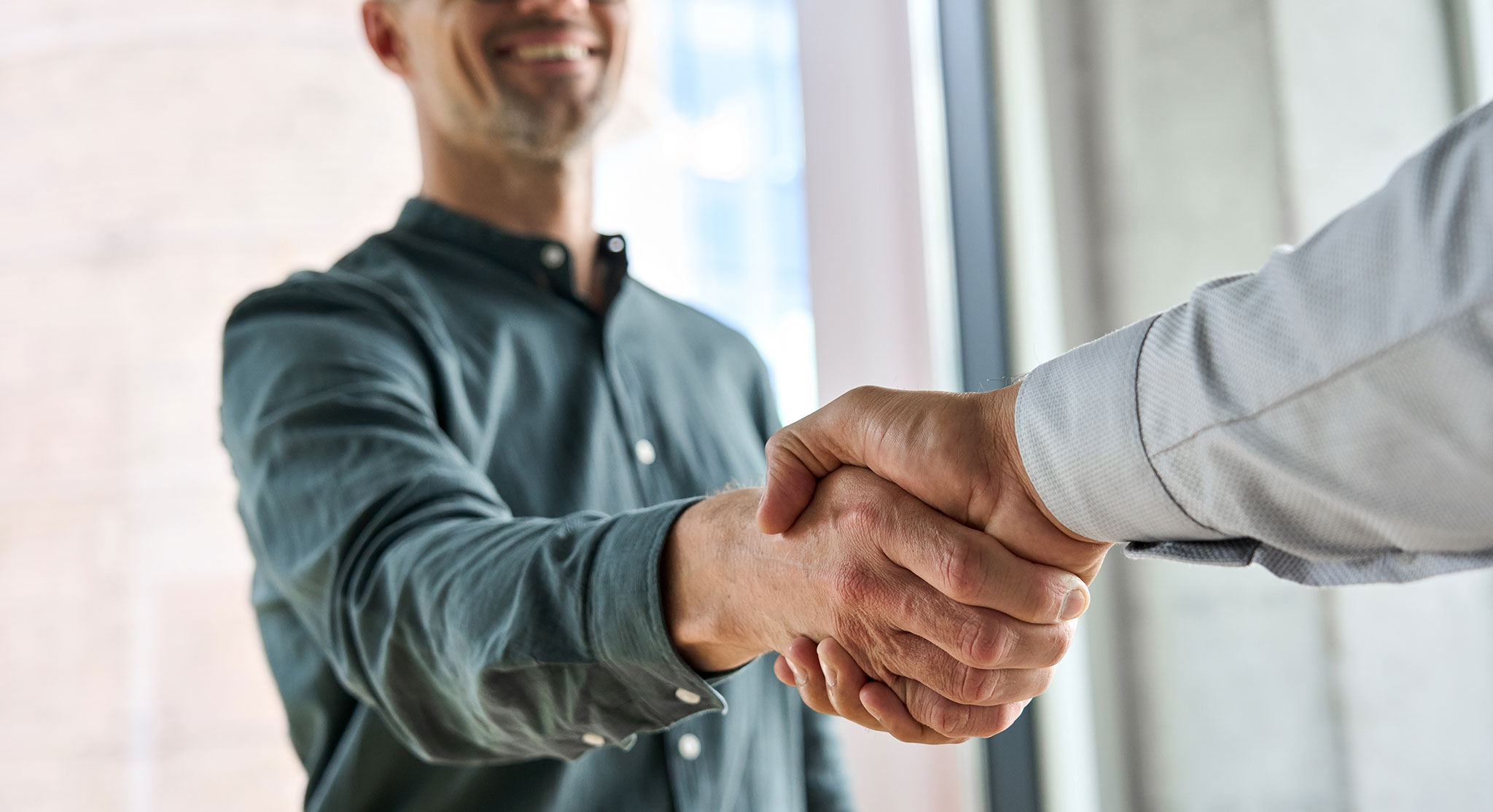 Two men creating partnership by shaking hands