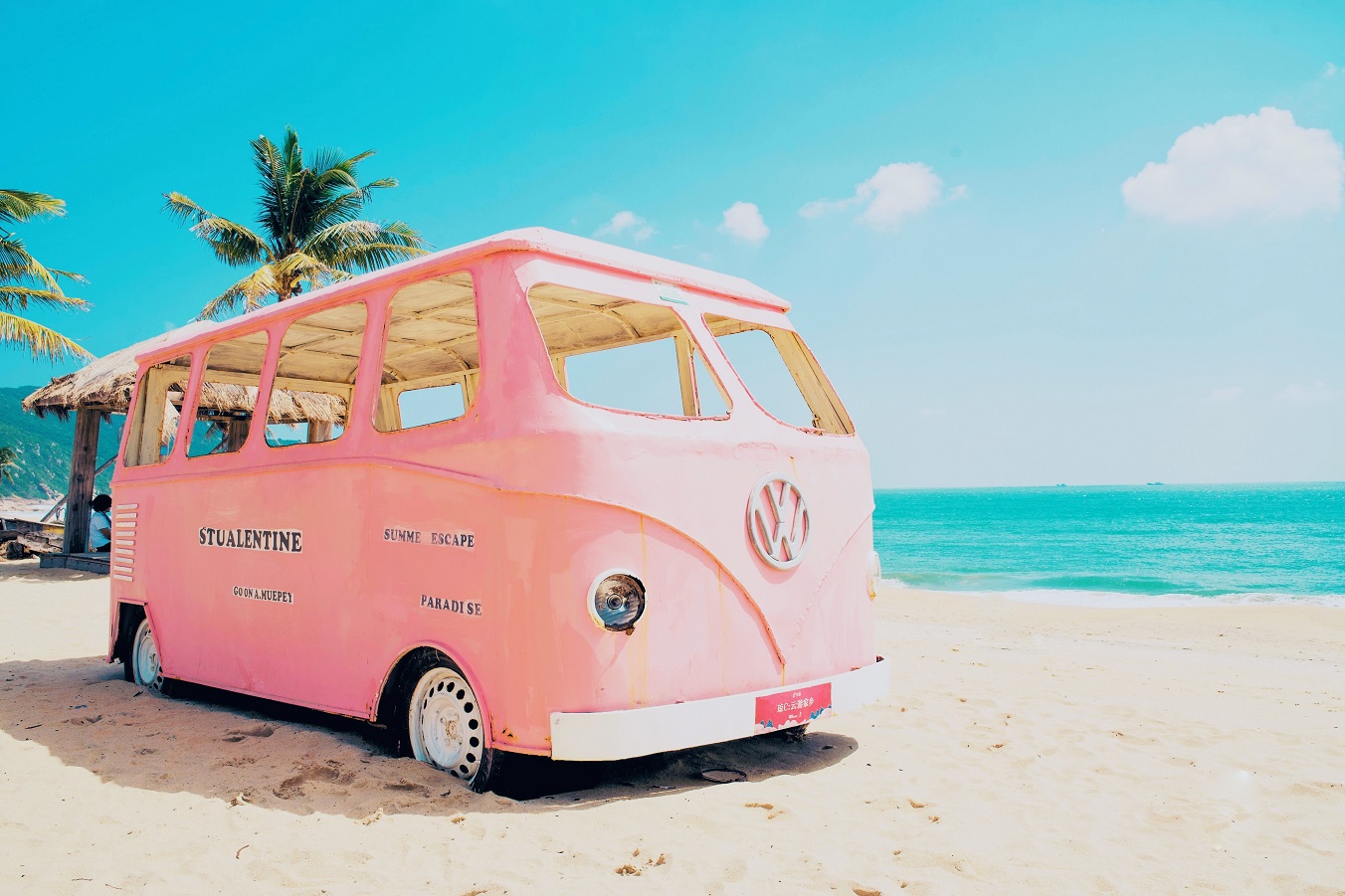 pink Volkswagen van on the beach with summer escape paradise stickers