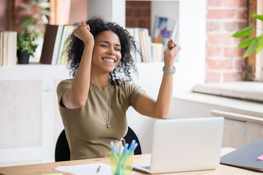 Women cheering in front on computer