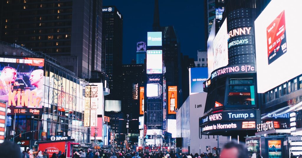 Nighttime shot of Time Square in New York City with many people walking around
