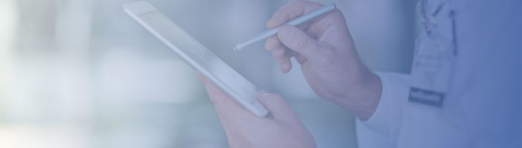 close up of hands in a white lab coat using a stylus on a tablet