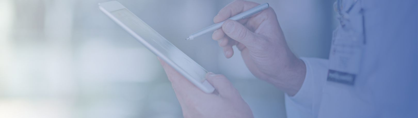 close up of hands in a white lab coat using a stylus on a tablet