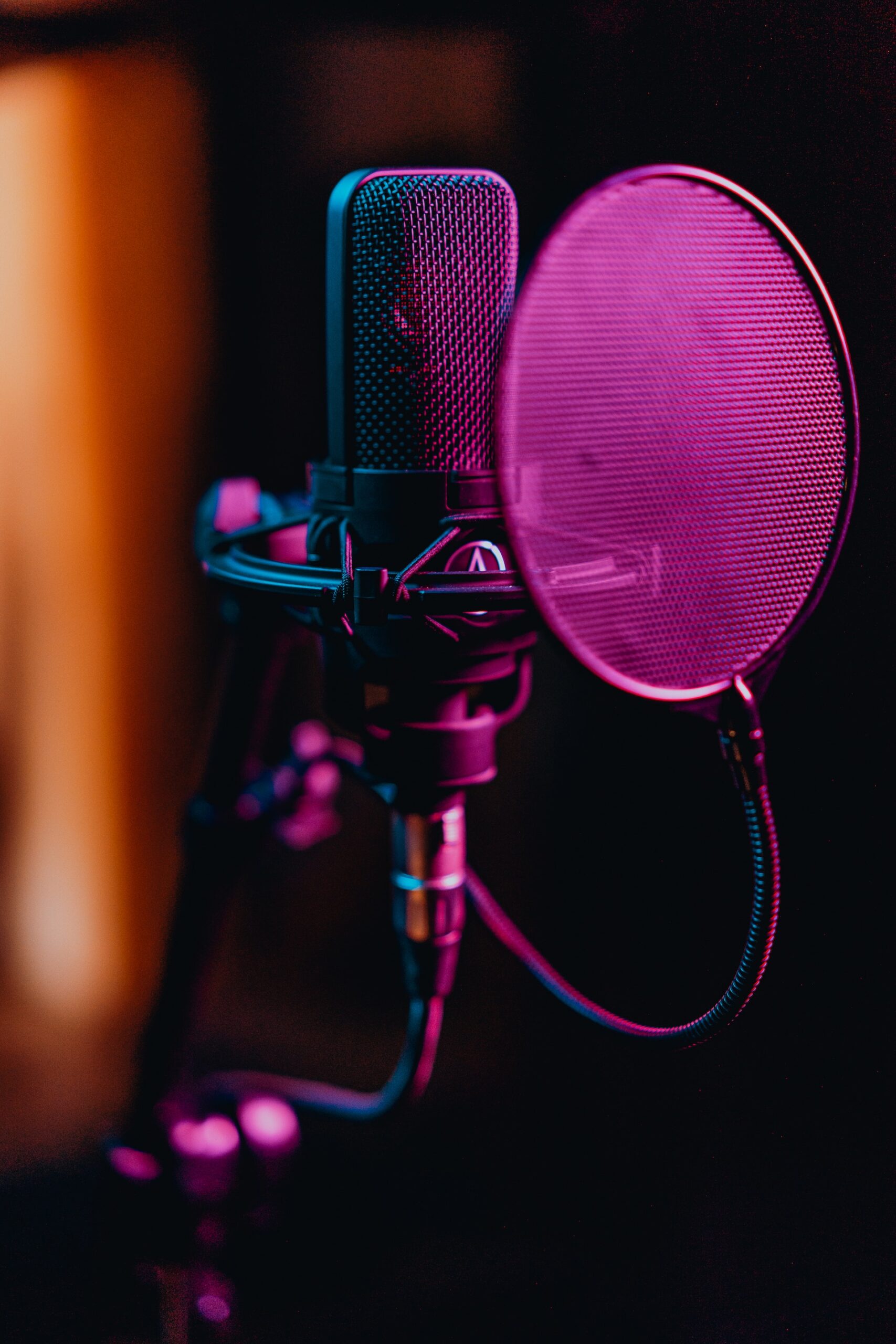 Close up of a microphone with a cover and pink lighting