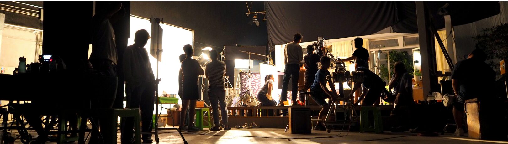 image of a production studio black room being lit with stage lighting as a crew works to set up a scene