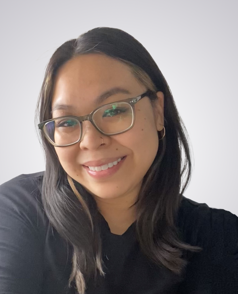Professional headshot of a black haired women smiling wearing a black long sleeve shirt on a white background
