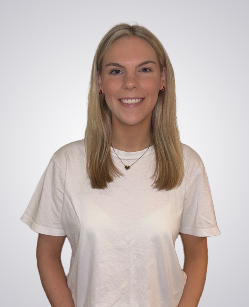 Professional headshot of a blonde women smiling wearing a white t-shirt on a white background