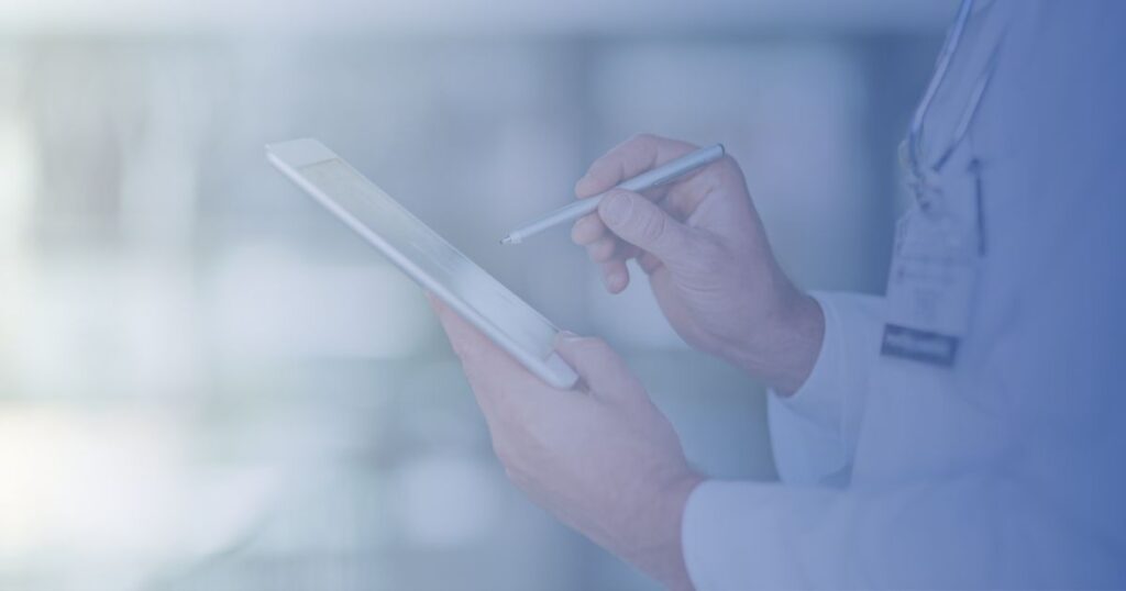 close up of hands in a white lab coat using a stylus on a tablet