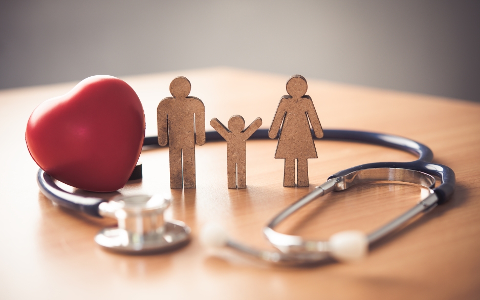 Stethoscope wrapped around a heart and a wooden family
