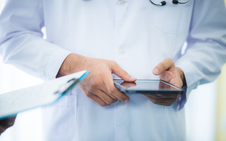 Doctor typing something into an iPad