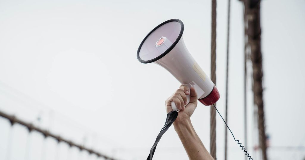 megaphone being raised in the air with one hand