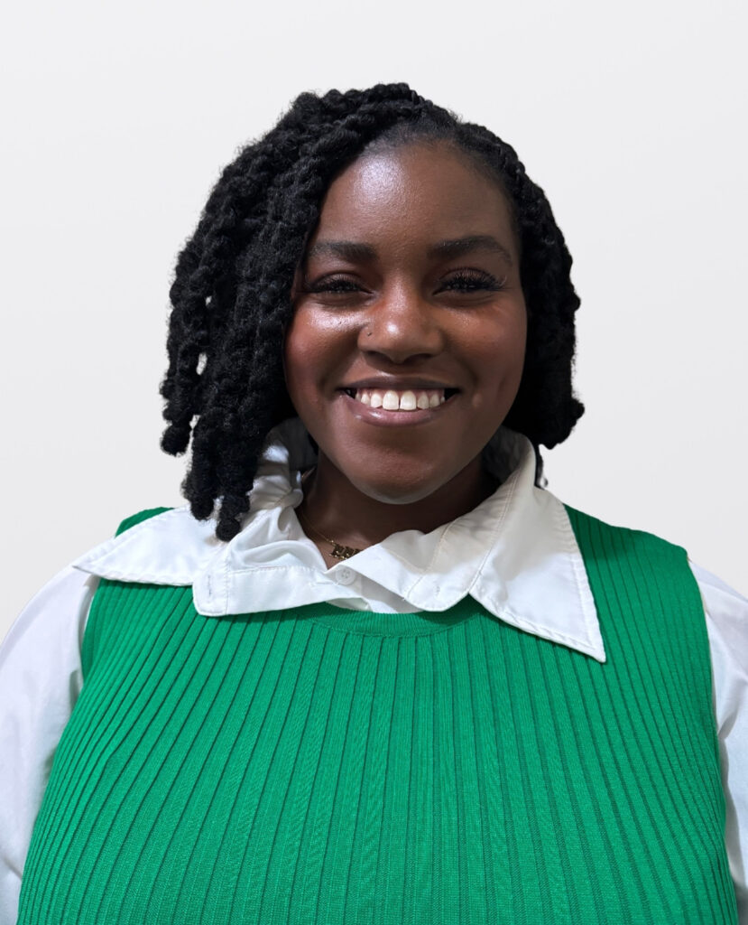 Professional headshot of a woman smiling wearing a green sweater