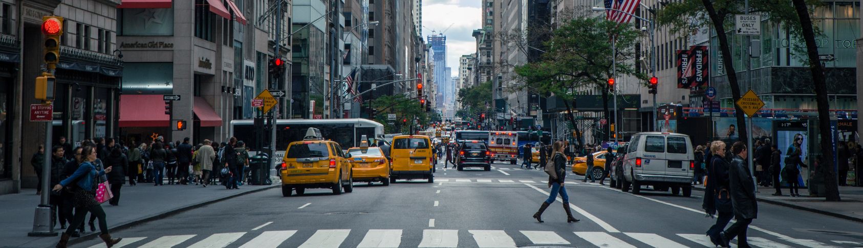Busy city crosswalk with people and cars