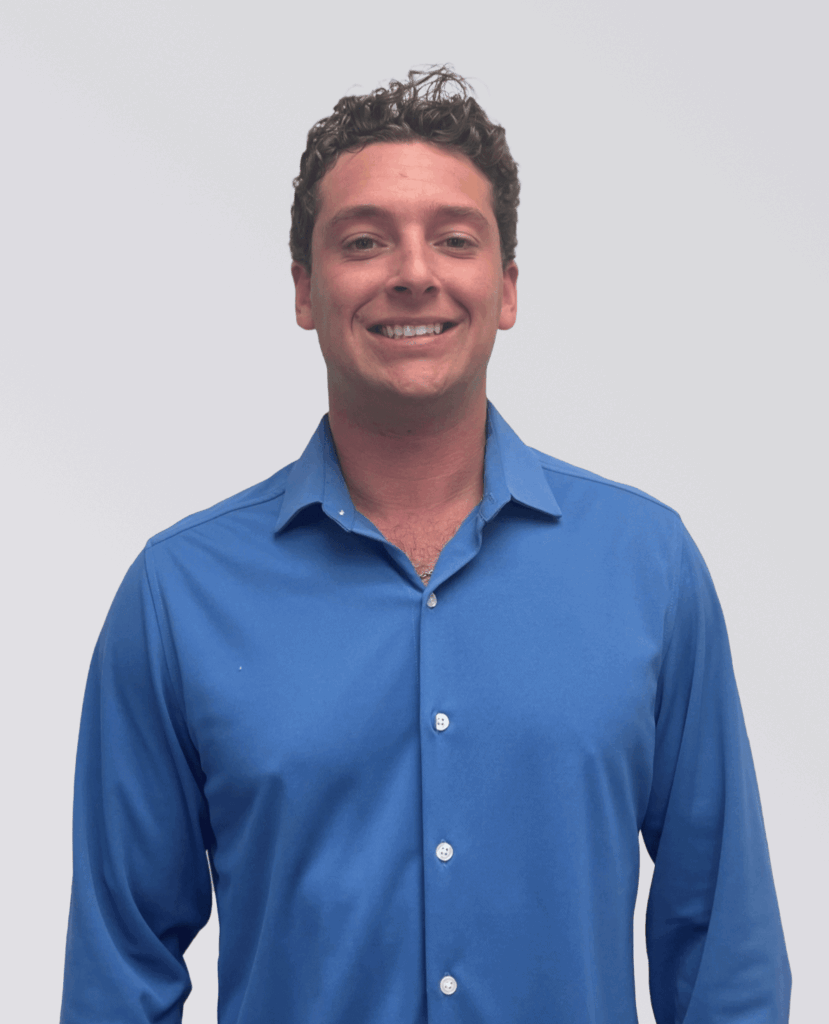 Smiling professional headshot of a man in a blue button up.
