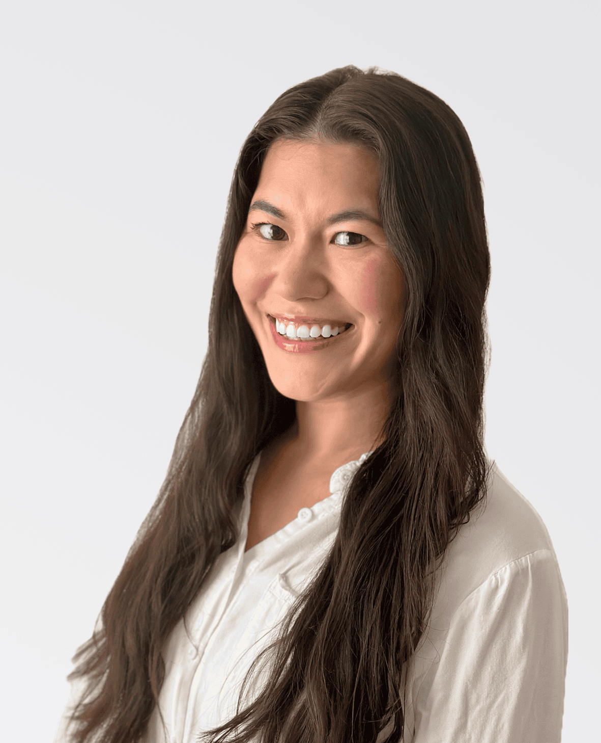 Professional headshot of a smiling woman in a white shirt