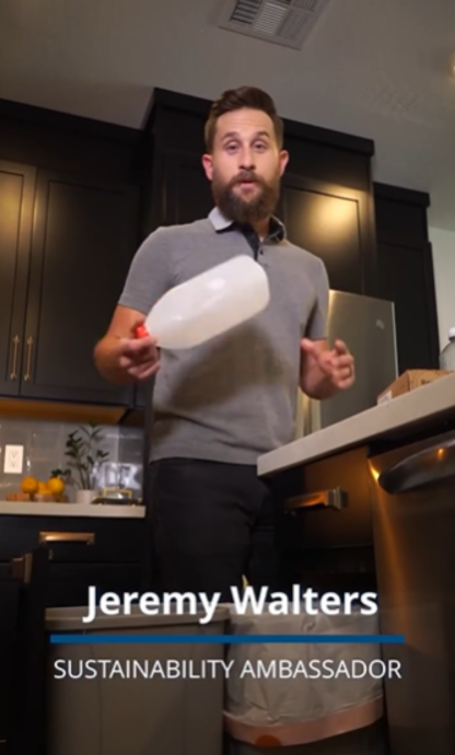Man holding plastic bottle talking to camera