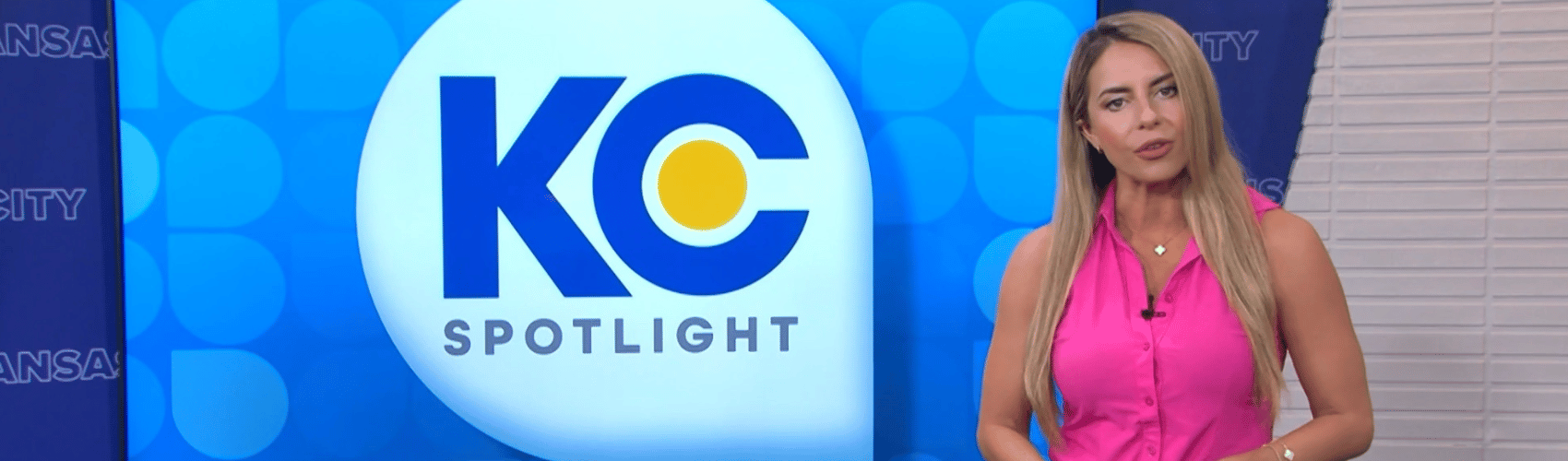 News Anchor standing in front of large screen